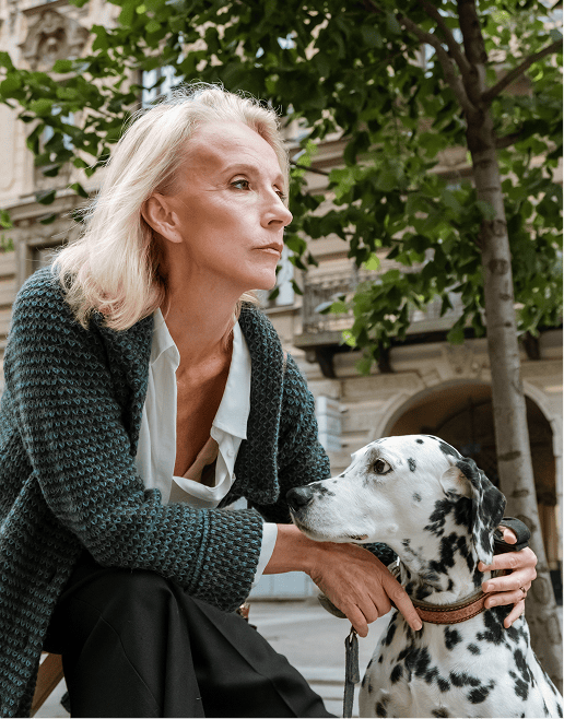 Frau mit Dalmatiner-Hund vor einer begrünten Altbaufassade