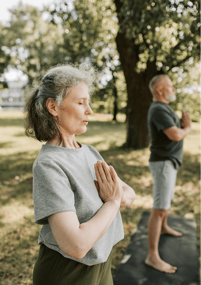 Älteres Paar macht Yoga-Übungen im grünen Park