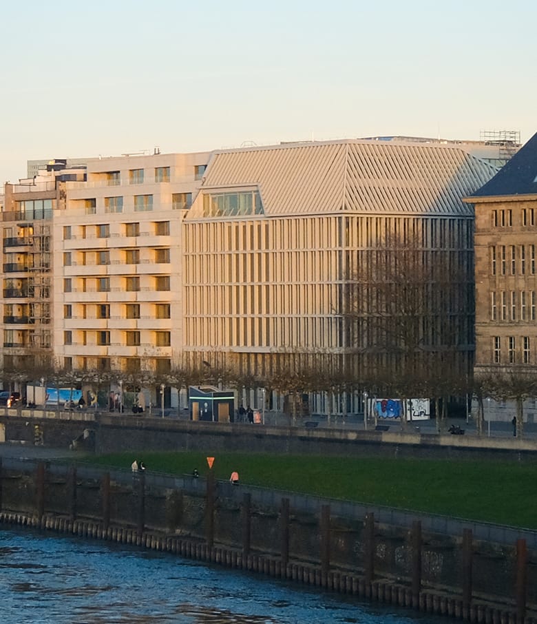 Modernes Gebäudeensemble am Spreeufer mit Uferpromenade und Grünstreifen