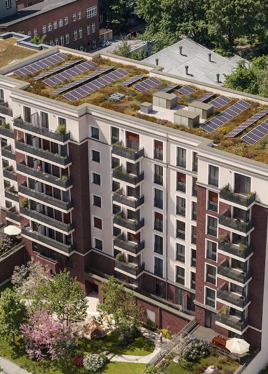 Luftnahaufnahme des begrünten Daches mit Solaranlage über den Klinkerbalkonen und Innenhofgarten