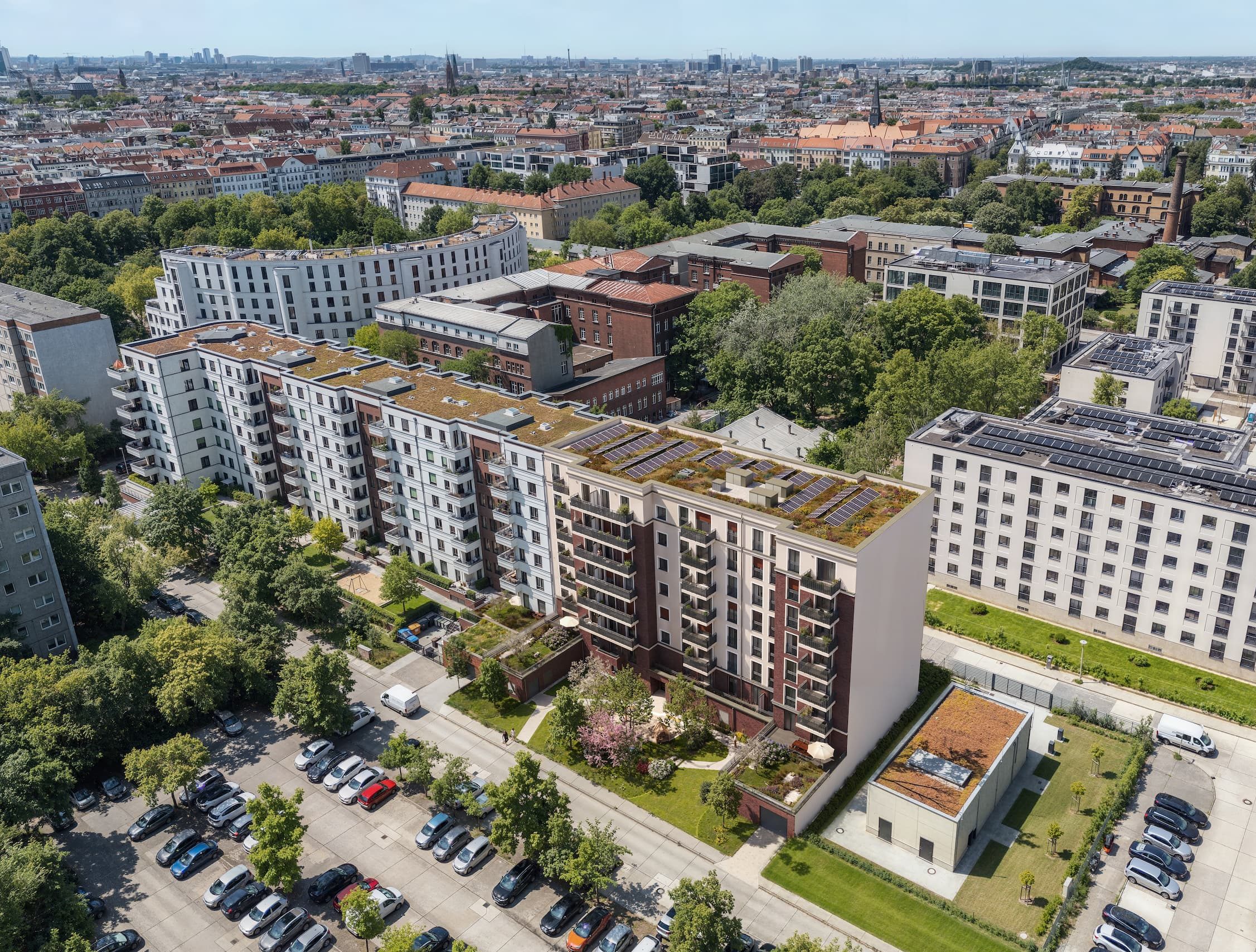Luftaufnahme des ELLA LIVING Wohnquartiers mit Solardächern vor der Berliner Stadtsilhouette