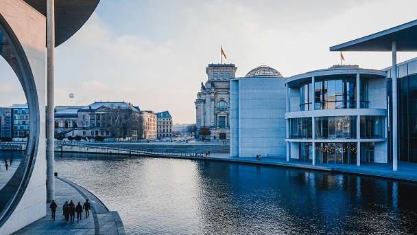 Reichstag und moderne Regierungsgebäude an der Spree mit Spaziergängern im Vordergrund