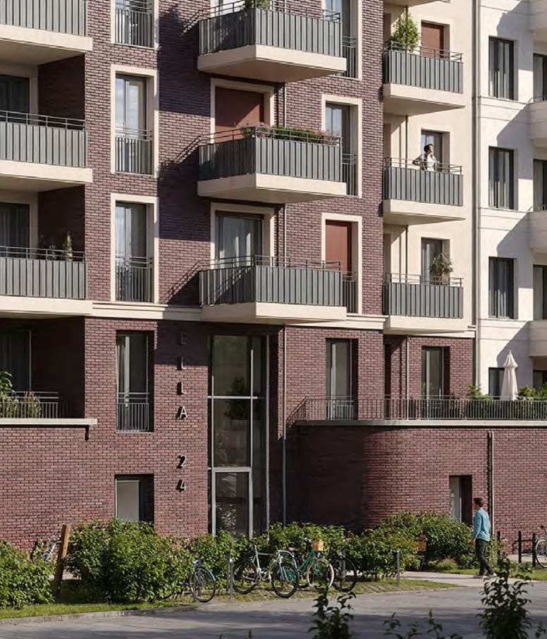 Klinkerfassade des Ella Living mit Hauseingang, Balkonen und abgestellten Fahrraedern