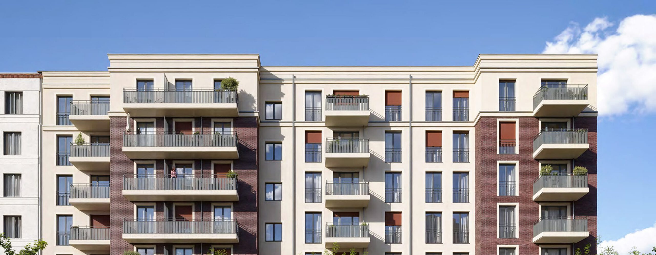 Moderne Wohnhausfassade in Beige und Backstein mit umlaufenden Balkonen vor blauem Himmel