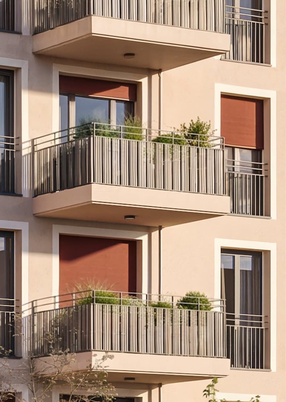 Detail der Fassade mit auskragenden Balkonen und orangefarbenen Sonnenmarkisen im Abendlicht